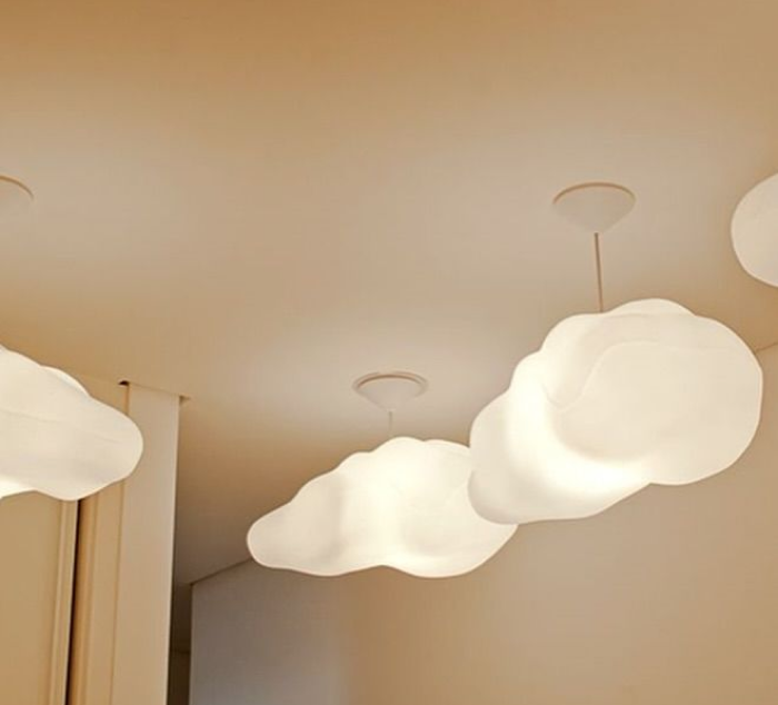 A iluminação adequada transforma o ambiente em um espaço relaxante, contribuindo para o bem-estar e o sono das crianças. Quarto infantil com luminária temática em forma de nuvem e luzes suaves.