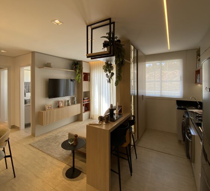 Este é um exemplo prático do que foi explicado no blogpost. O decorado do Benvindo traz sala, jantar e cozinha conectadas de forma harmoniosa, criando uma área social fluida e convidativa. Sala integrada com cozinha americana no decorado do Benvindo.
