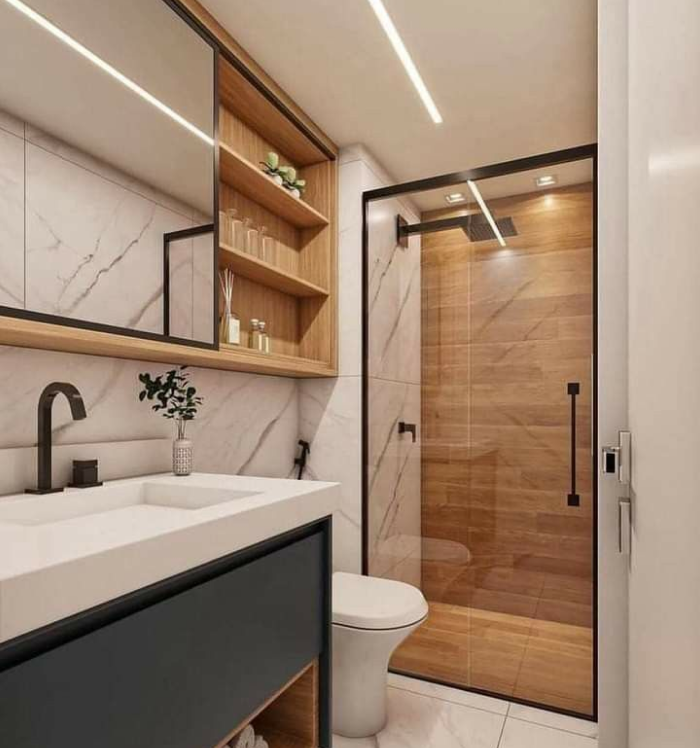 Banheiro decorado com porcelanato branco e detalhes em azul, mostrando como materiais práticos e modernos valorizam ambientes compactos. Banheiro claro com revestimento em porcelanato branco e armário azul sob a pia.